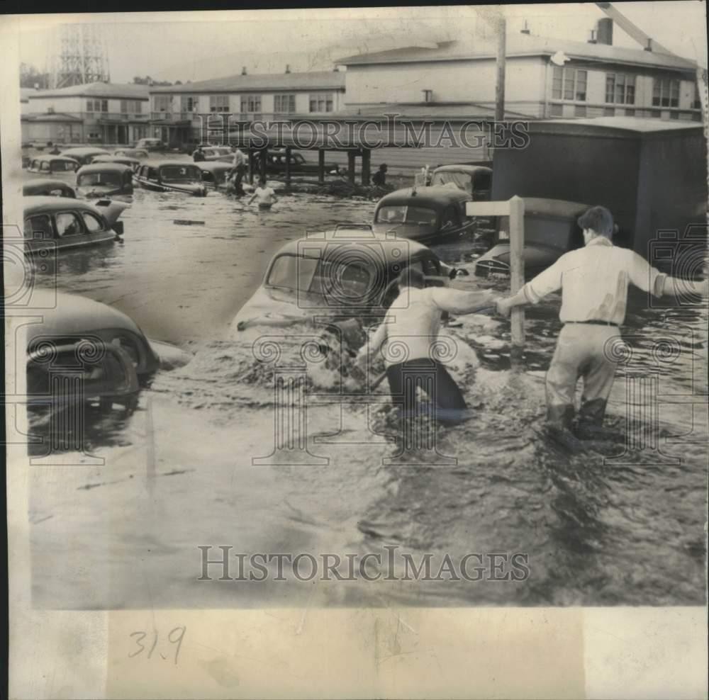 Press Photo People walking through a flooded city street – mjc39223