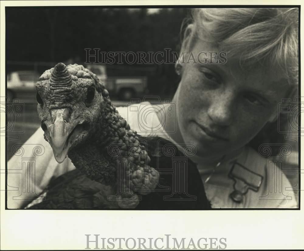 1985 Press Photo Child looks fondly at his turkey. – noc73508