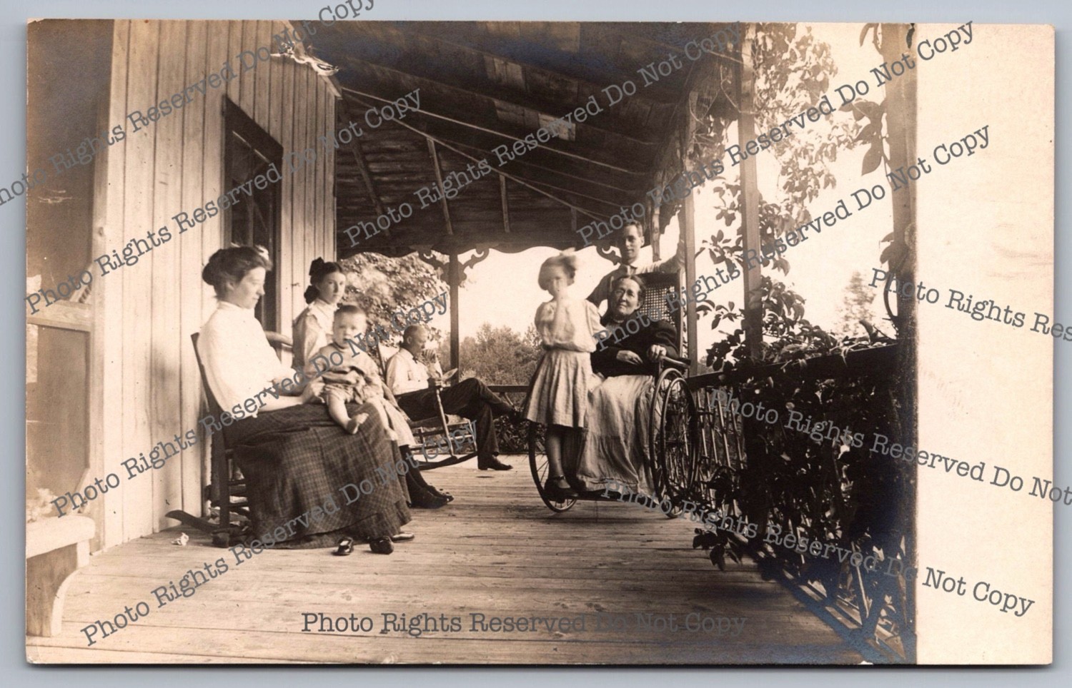 Antique RPPC women men children on porch relaxing wheelchair Real Photo Postcard