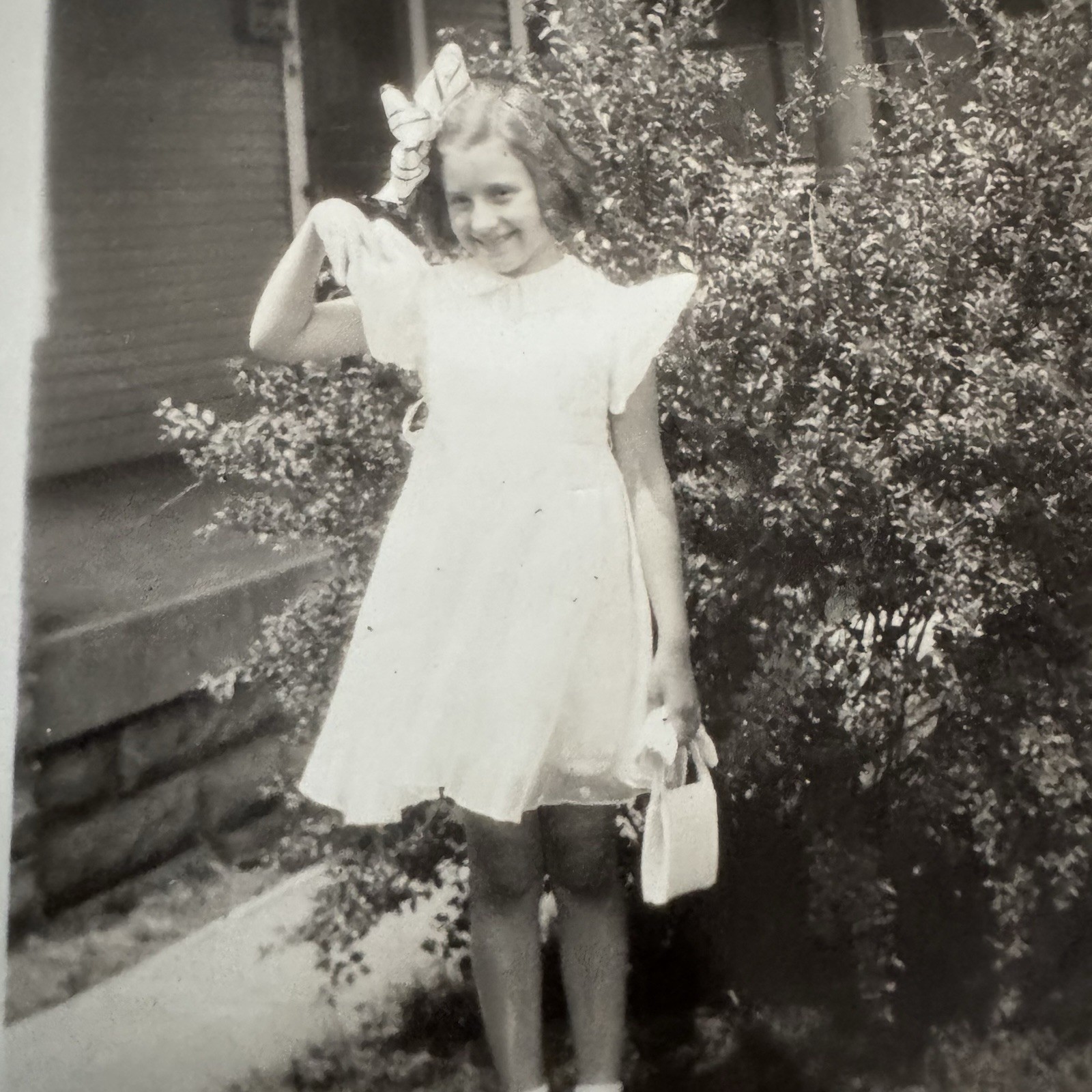 Vintage Old Candid Snapshot Photo Portrait Young Girl Standing w/bow, bag, Dress