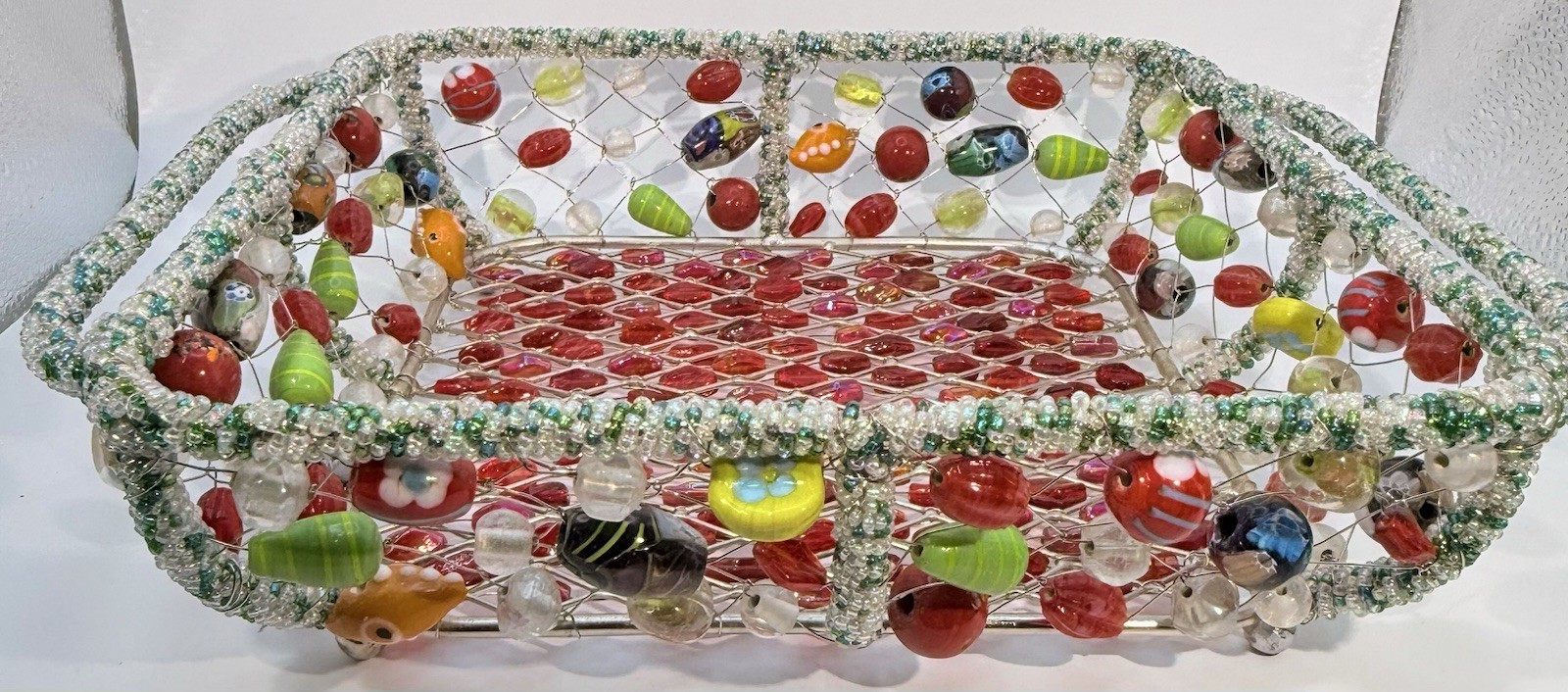Decorative wire and glass bead basket with multicolored beaded embellishments