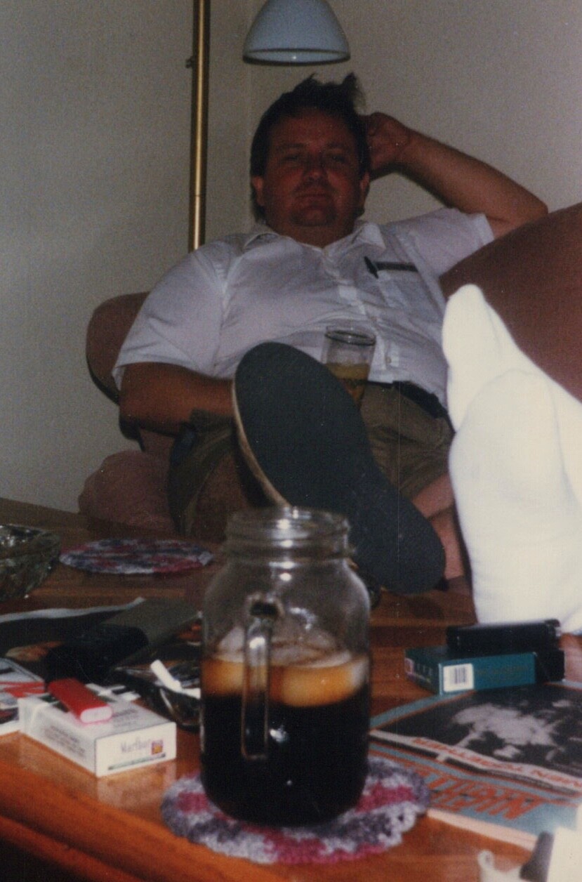 Candid Moment Chubby Man Relaxing Indoors with Beverage 1980s