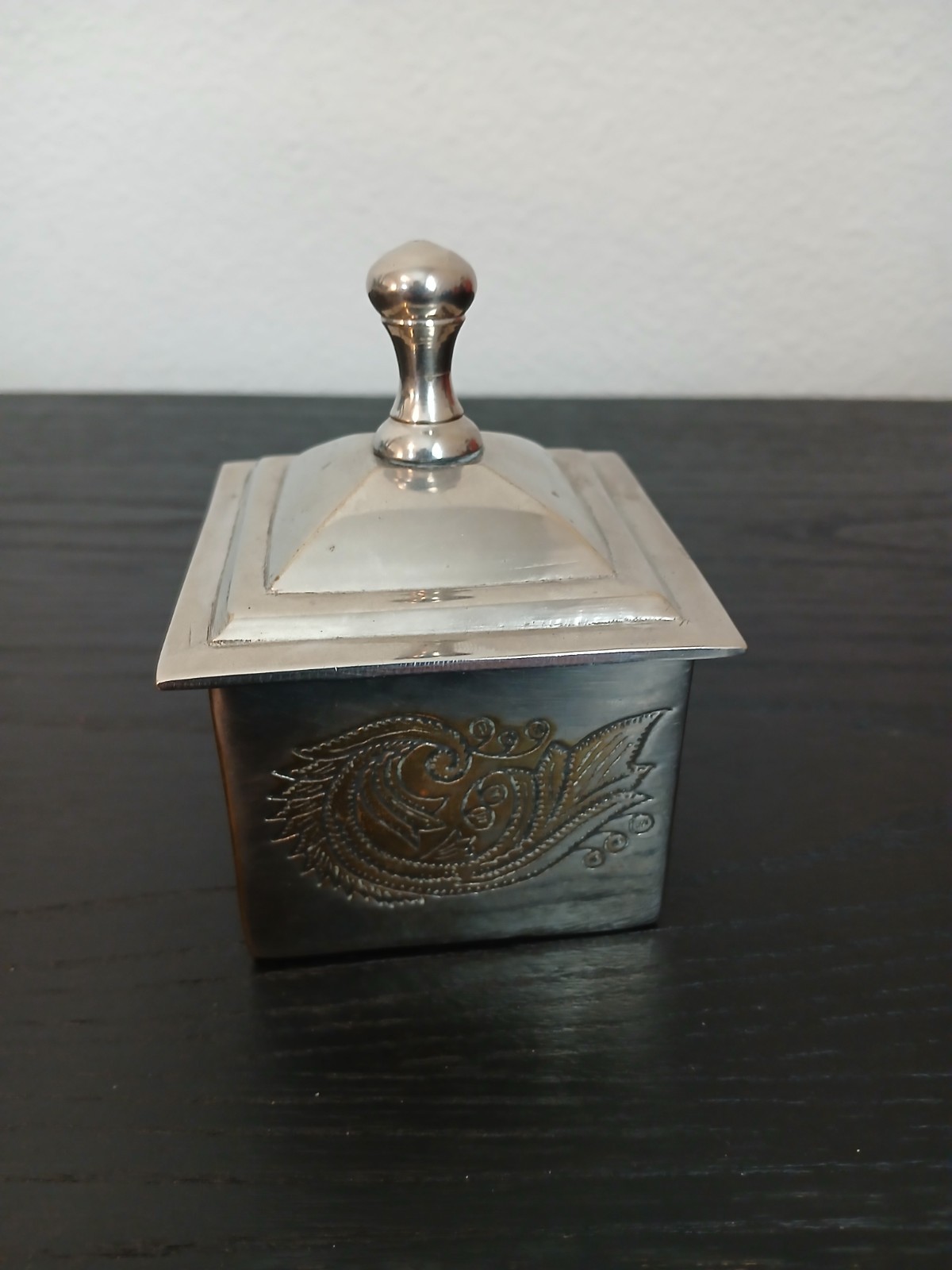 silver-plated trinket box featuring an engraved design and a lid with a knob
