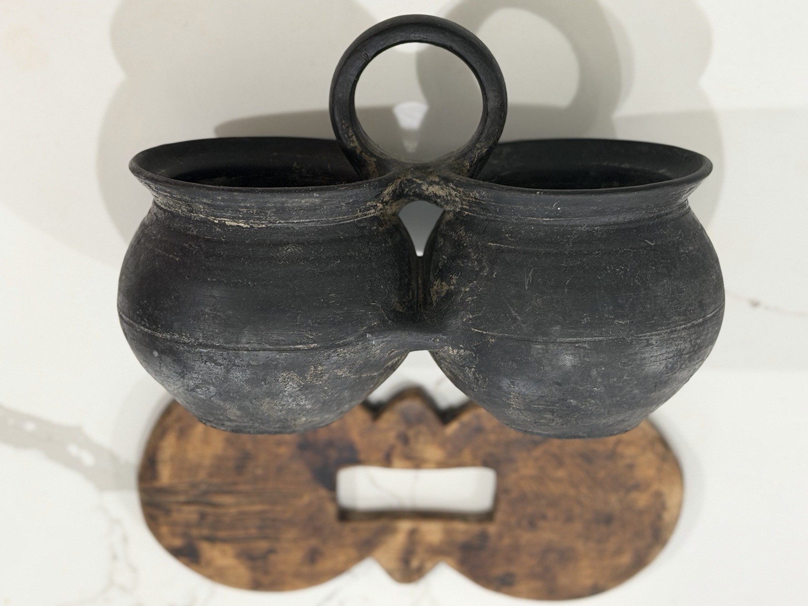 antique,specifically a ceramic double jar with a wooden lid and a black handle.