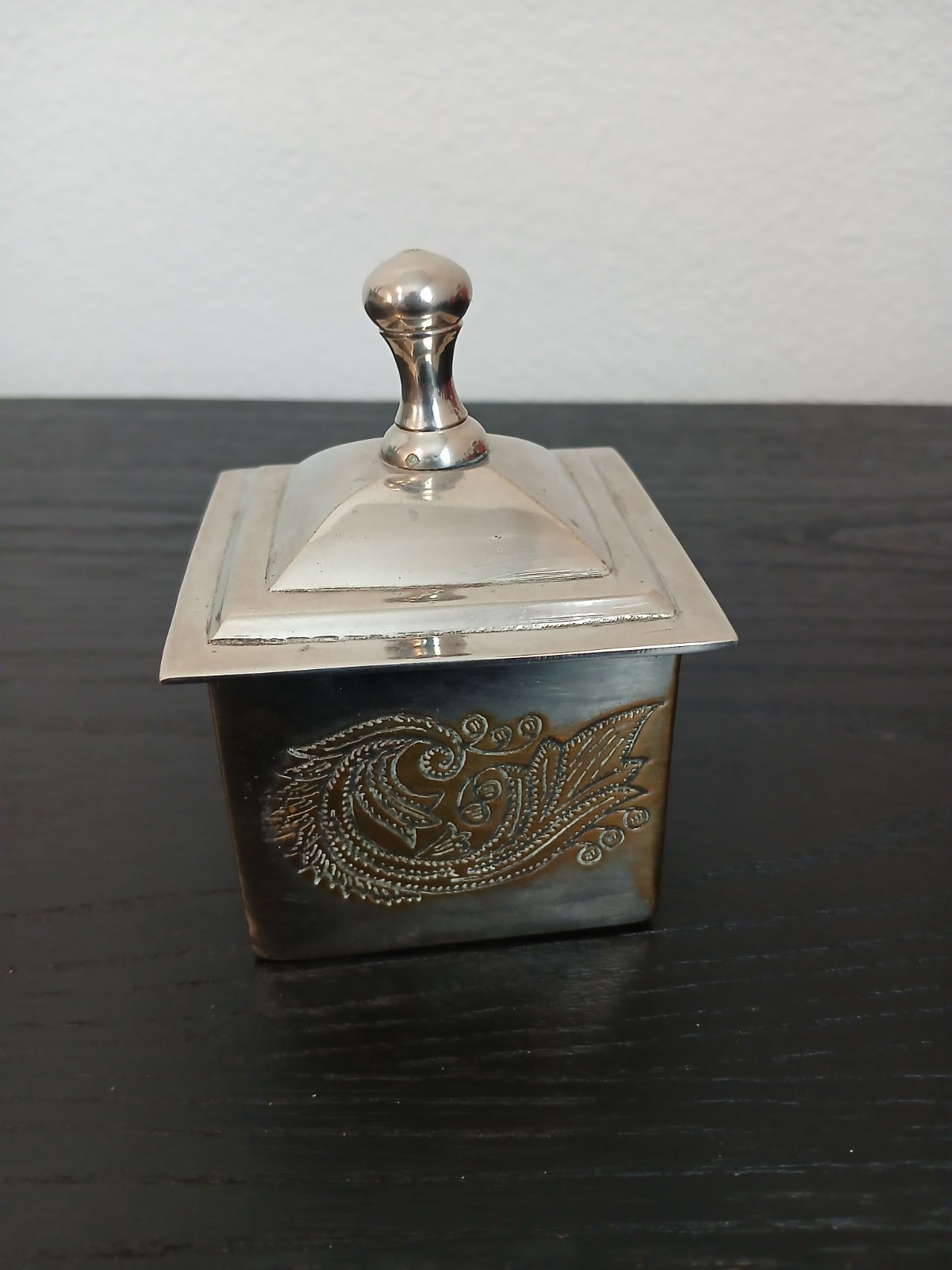 silver-plated trinket box featuring an engraved design and a lid with a knob